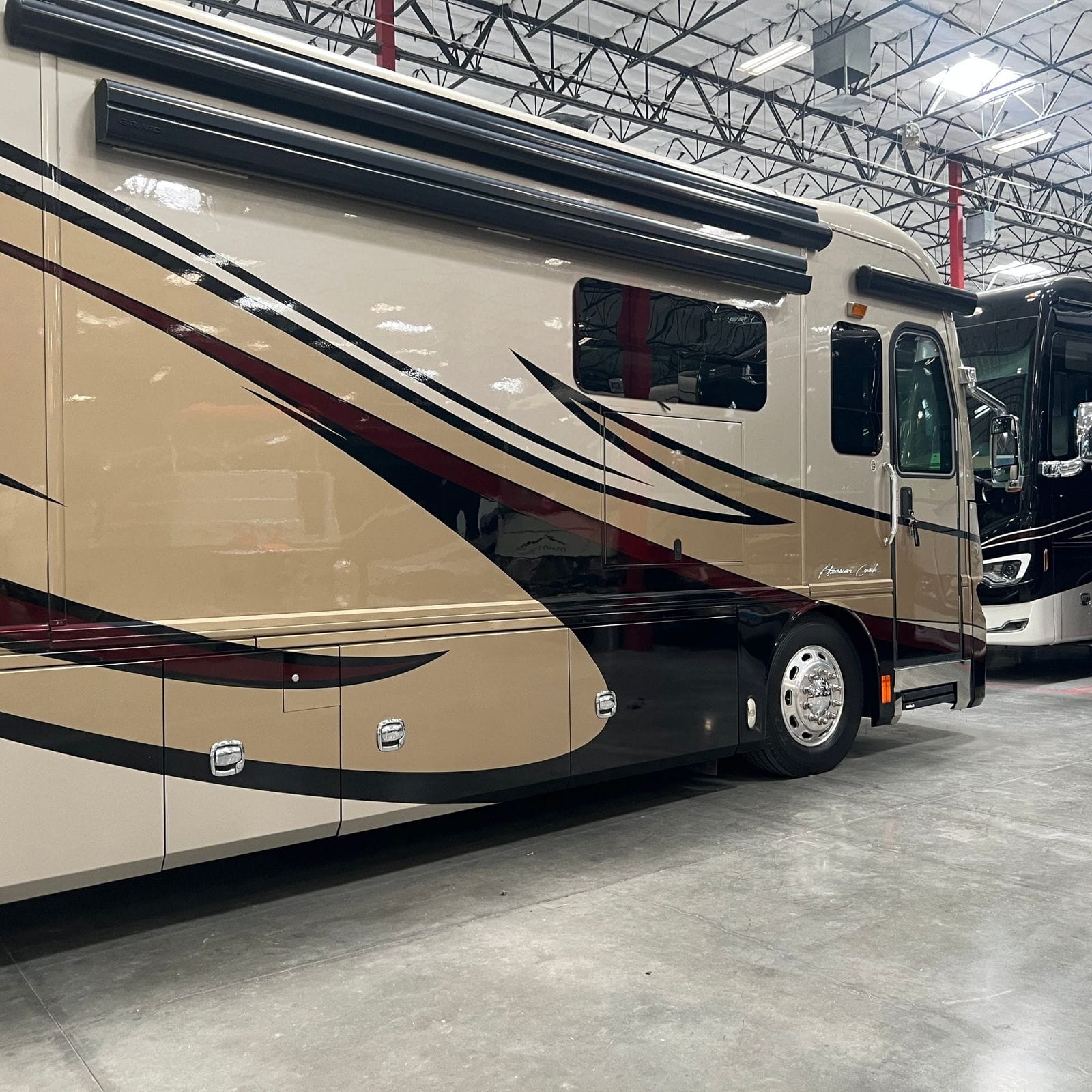 2013 American Coach American Revolution 42T angled passenger-side three-quarter at the entry door and cab area