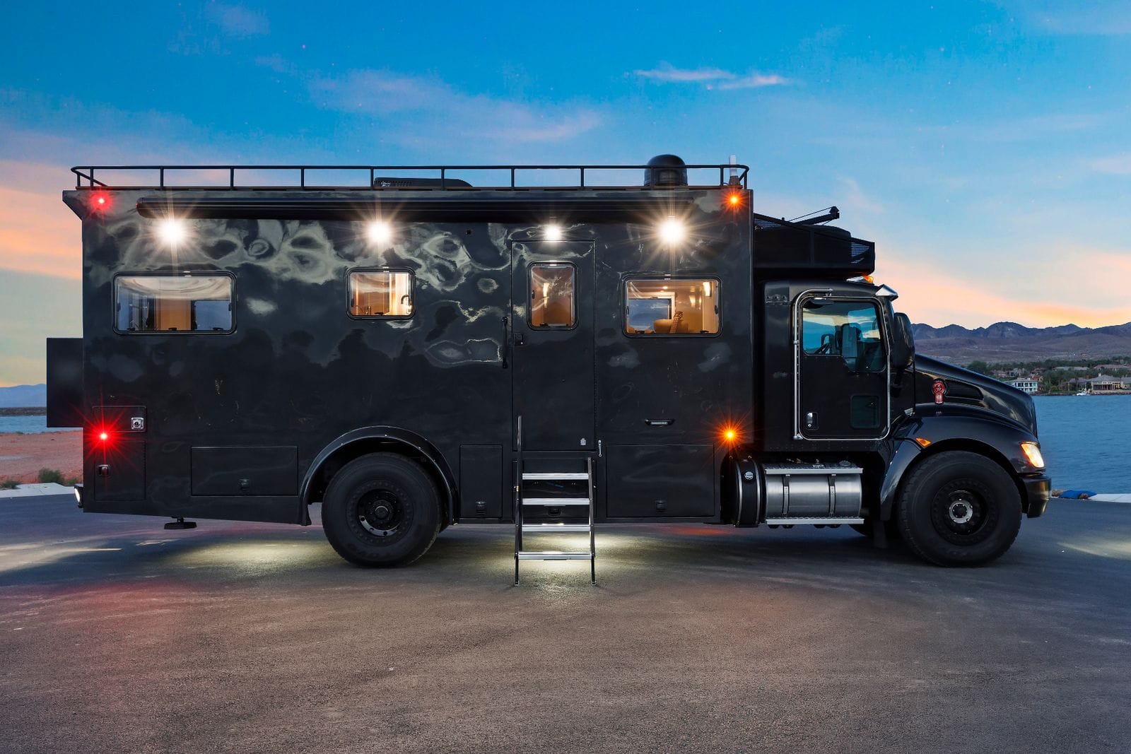 2017 Global Expedition Vehicles The Beast full passenger-side profile of the expedition box body with pull-out entry stairs down, four camper windows, roof rail, awning and polished fuel tank behind the cab