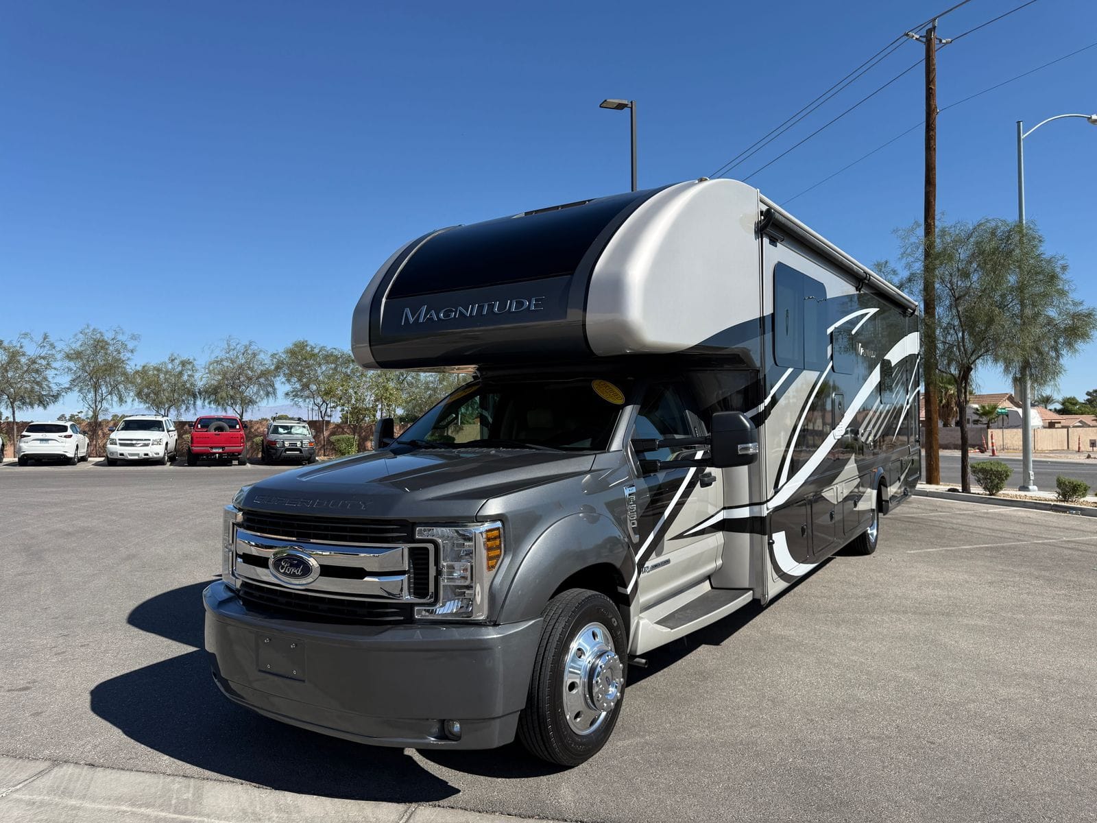 2020 Thor Magnitude BH35 front three-quarter view, showing the Magnitude badge on the cab-over, chrome Ford grille and polished aluminium wheels