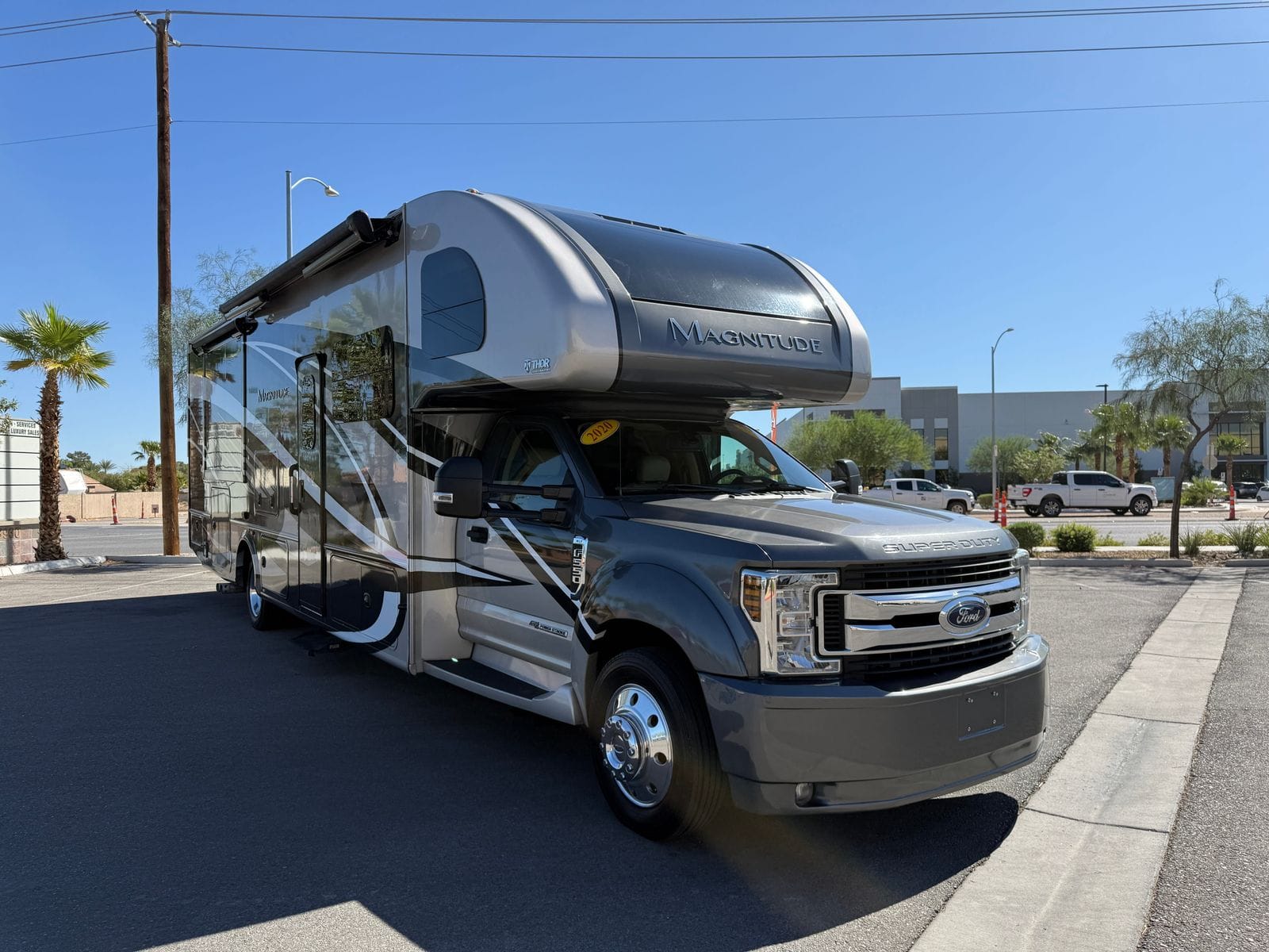 2020 Thor Magnitude BH35 front three-quarter view from a low angle, showing the Super Duty hood, dual rear wheels and the full length of the coach body