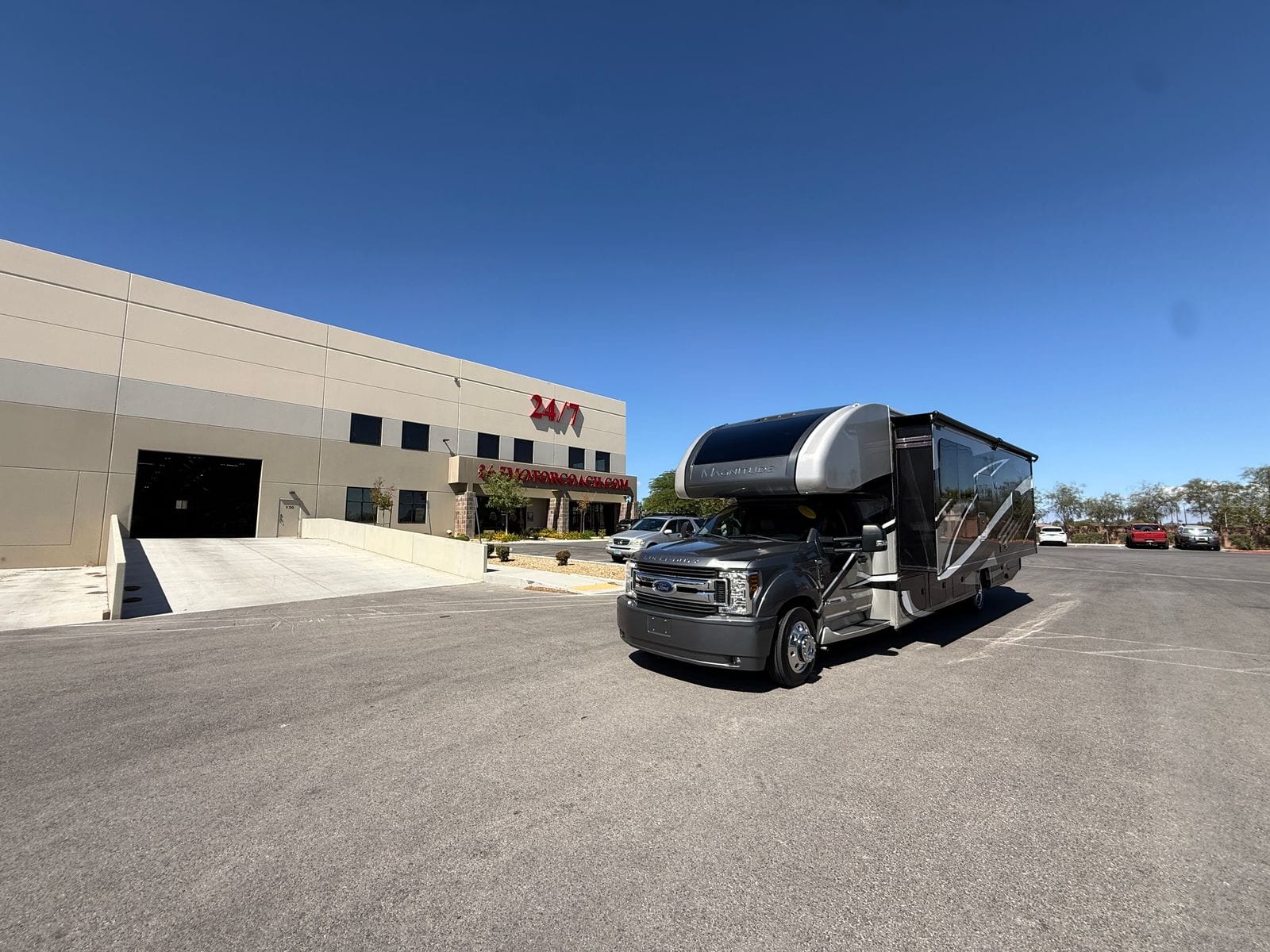 2020 Thor Magnitude BH35 front three-quarter view outside the 24/7 MotorCoach building, with the slide-out extended and the entry door open