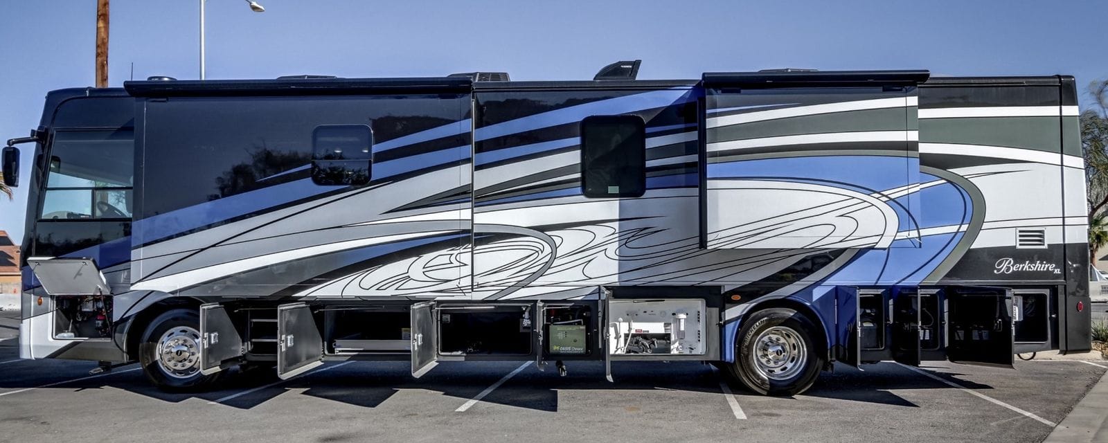 2024 Forest River Berkshire XL 40E full driver's-side profile with every basement bay door open and Berkshire XL badge on the rear cap