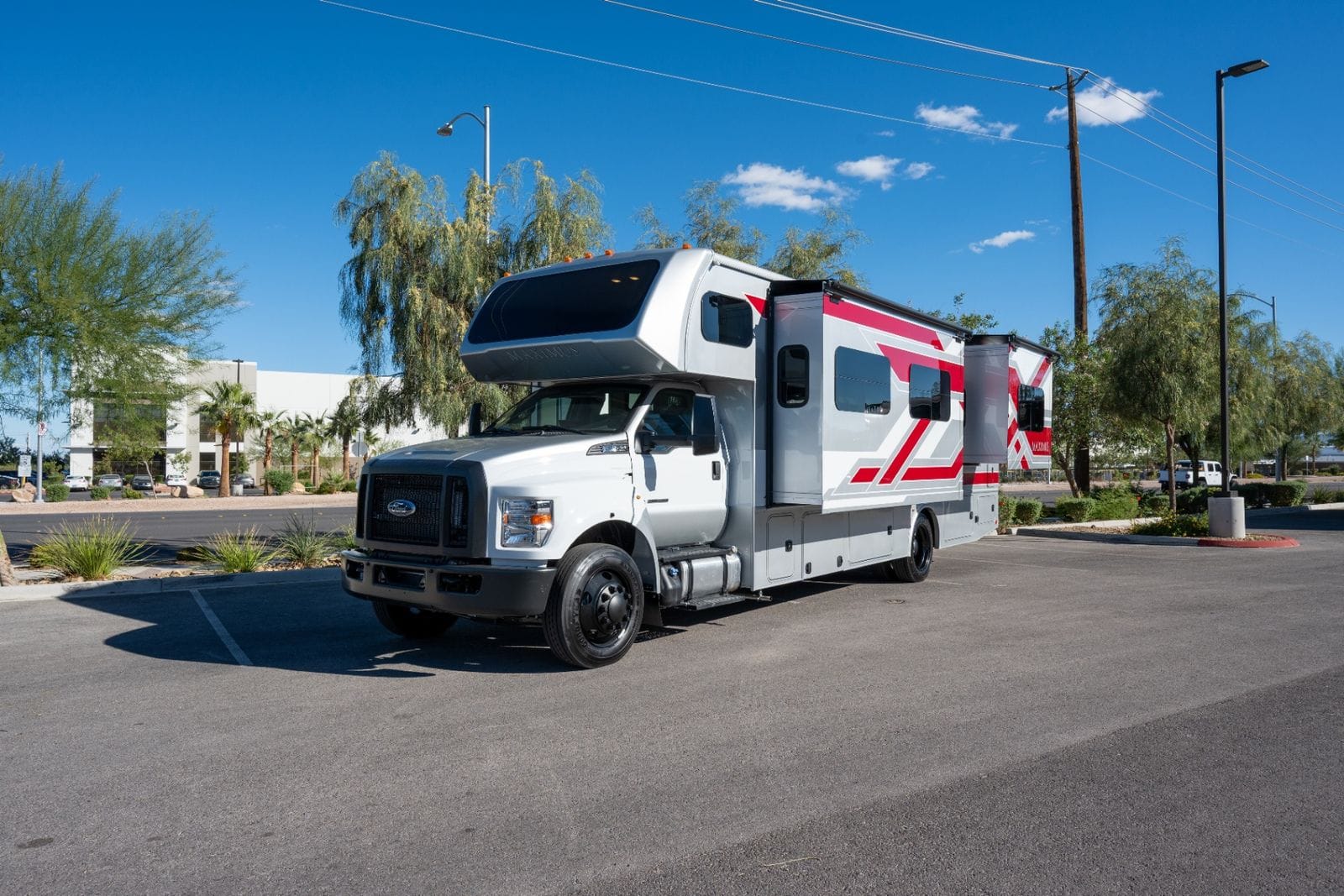 2026 Nexus Maximus 34MX front driver's-side three-quarter view with slide-outs extended and roof-mounted air conditioners