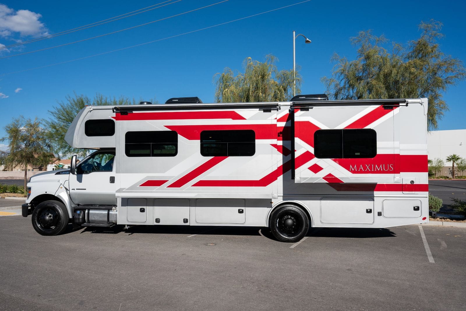 2026 Nexus Maximus 34MX full driver's-side profile showing red chevron full body paint, storage bays and 22.5-inch wheels