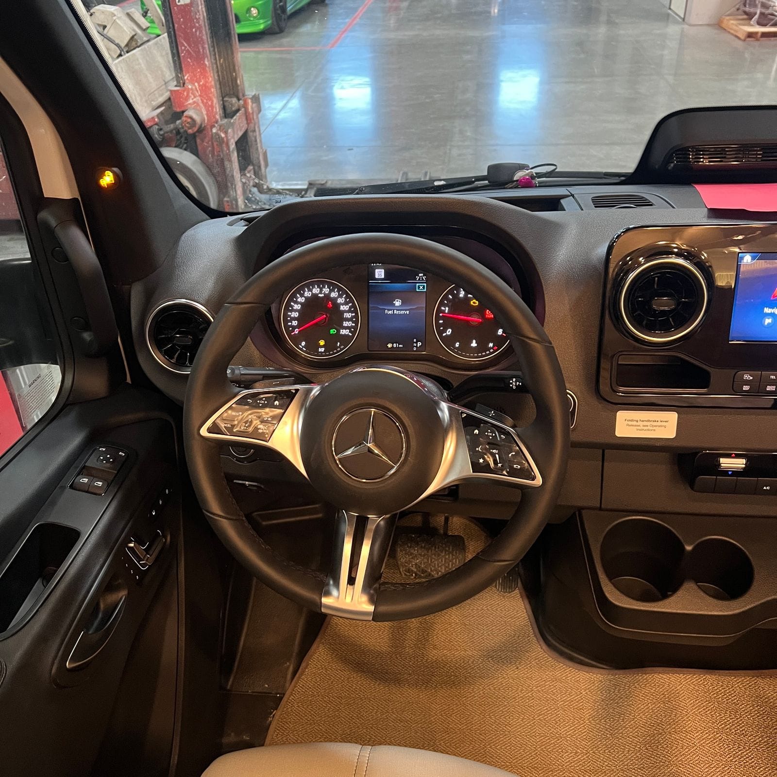 2026 Thor Delano 24XL driver's position showing the Mercedes-Benz multifunction steering wheel, speedometer and tachometer and the door switch panel