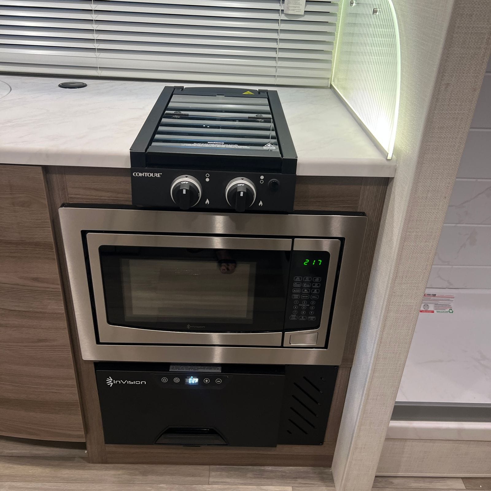 2026 Thor Delano 24XL close view of the two-burner cooktop with glass cover, stainless convection microwave and a black oven drawer below