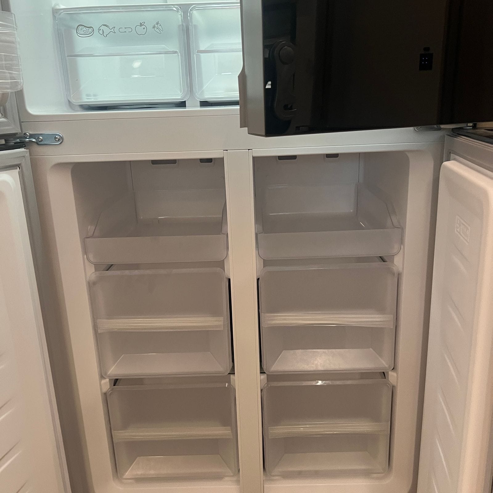 2027 Dynamax Europa S 37CA open lower freezer drawers showing white pull-out bins and clear upper storage trays