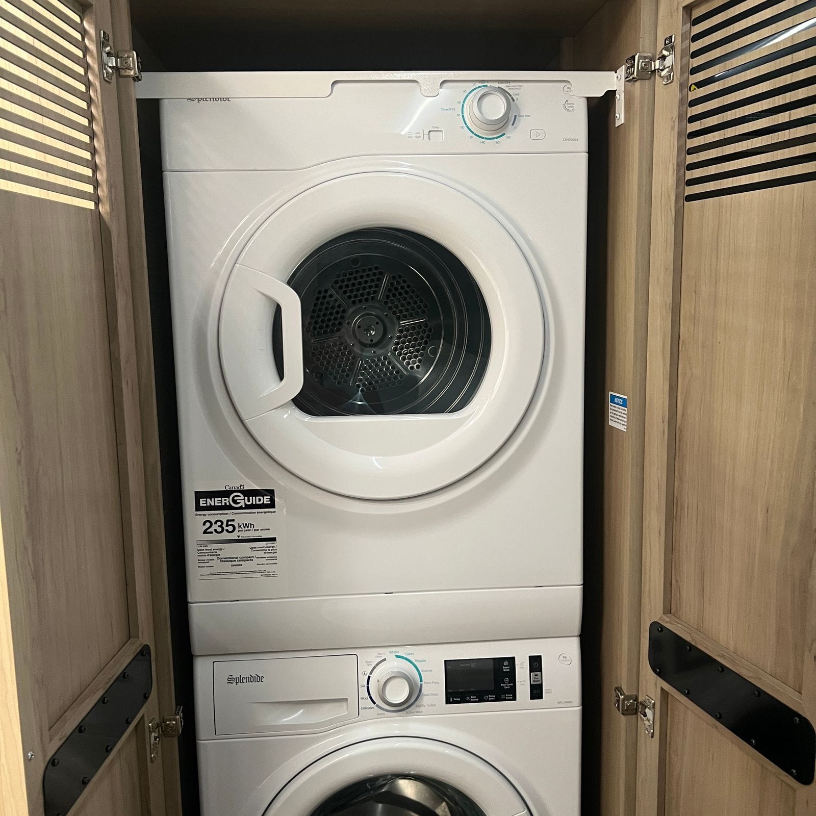 2027 Dynamax Europa S 37CA stacked washer and dryer inside a louvered light wood laundry closet