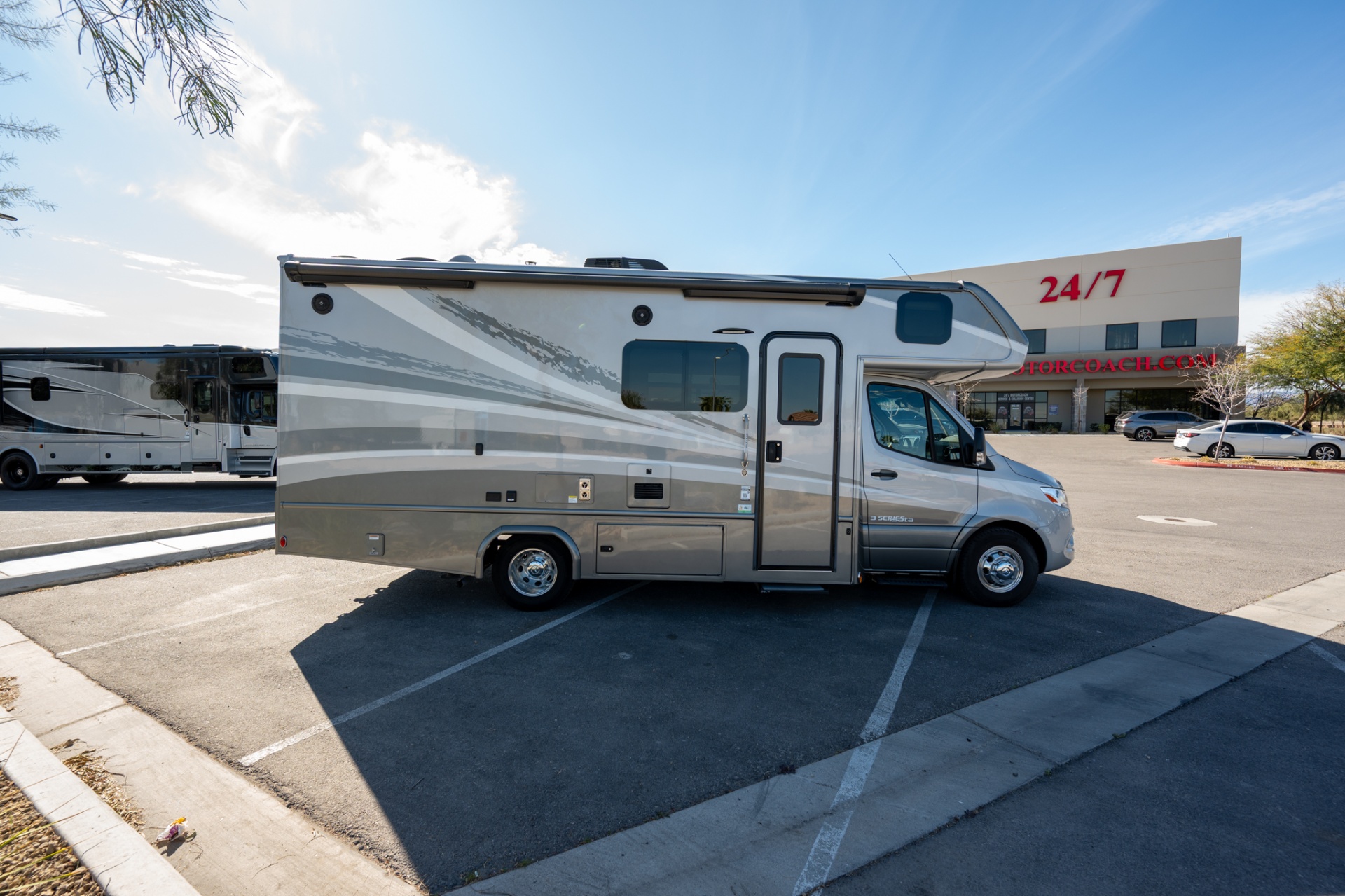 2025 Dynamax Isata 3 24FW passenger side with 24/7 building